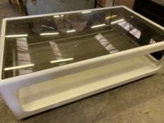 Glass top white plastic coated low table on castors