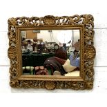 Ornately decorated gilt framed wall mirror