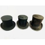 Two black silk top hats and an opera hat