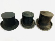 Two black silk top hats and an opera hat