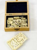 Wooden box containing miniature bone dominoes and a carved ivory puzzle