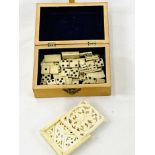 Wooden box containing miniature bone dominoes and a carved ivory puzzle