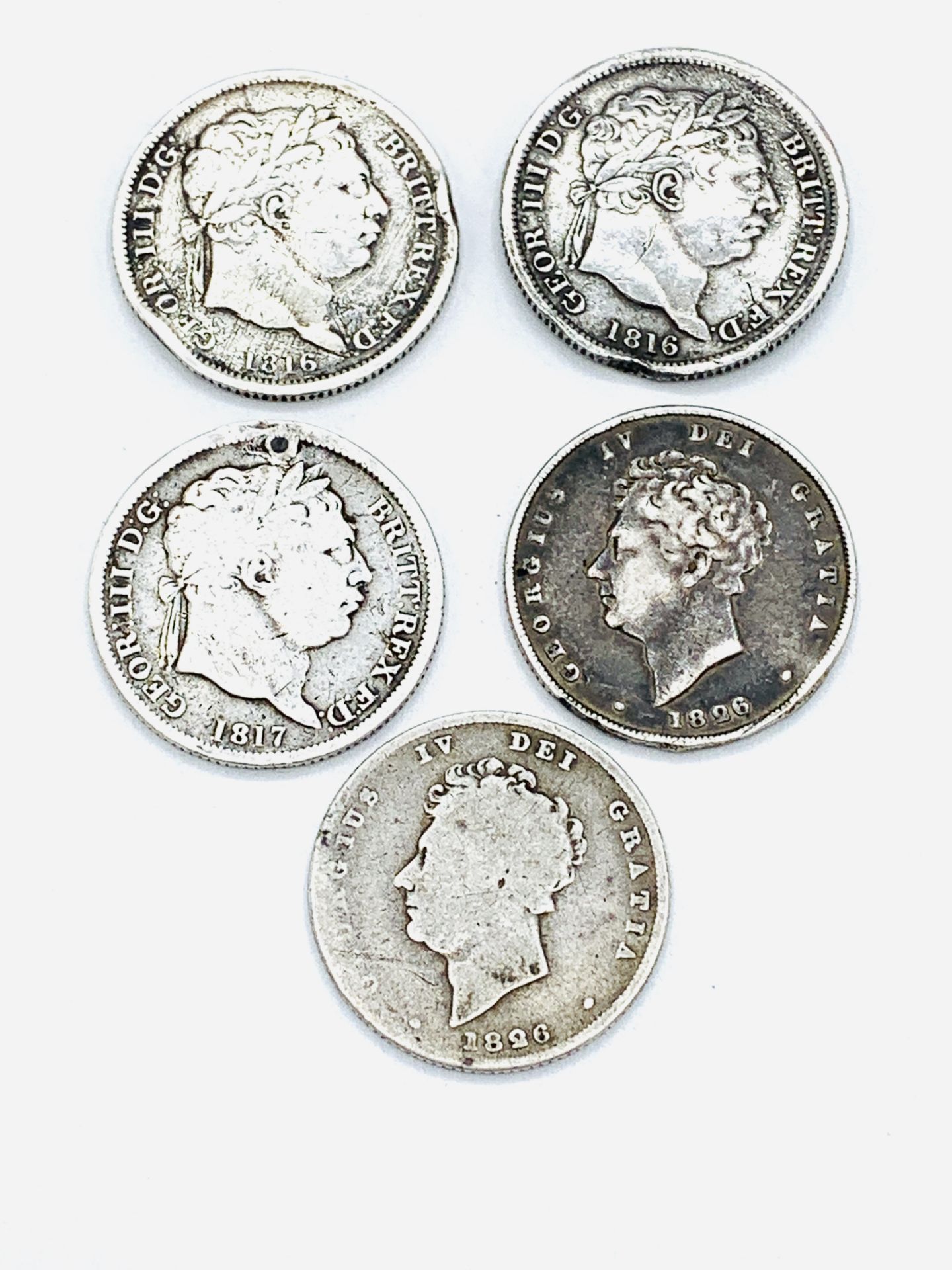 Five Georgian silver shillings and two Georgian silver sixpenny coins