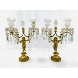 A pair of early 19th Century figural putti gilt bronze and crystal glass candelabra