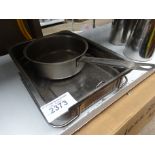 Two baking trays and a saucepan