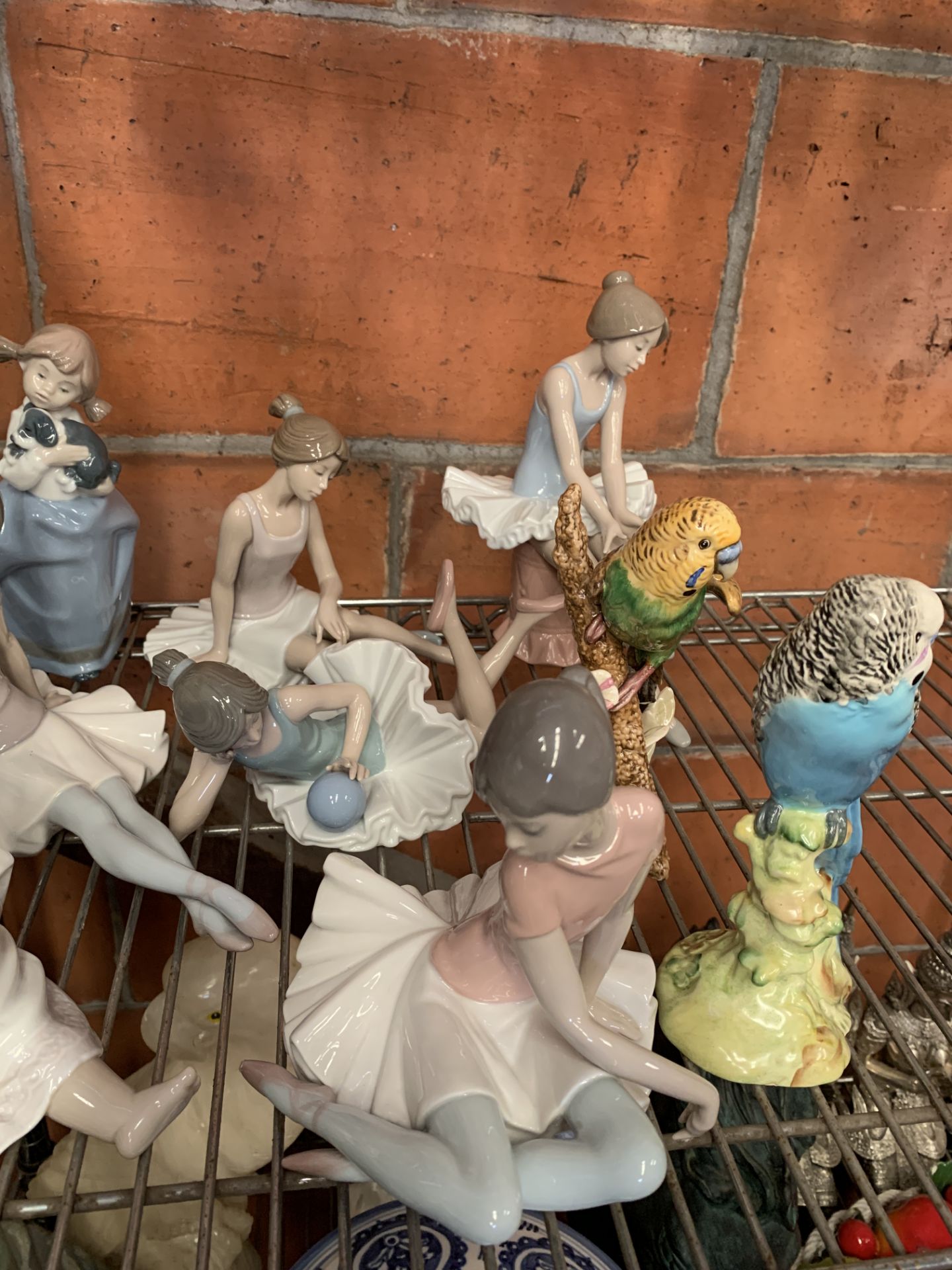A quantity of Lladro and Nao figurines, a Beswick budgerigar and a Goebel budgerigar