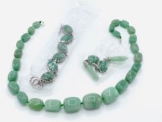 A green jade bead necklace, bracelet, and drop earrings