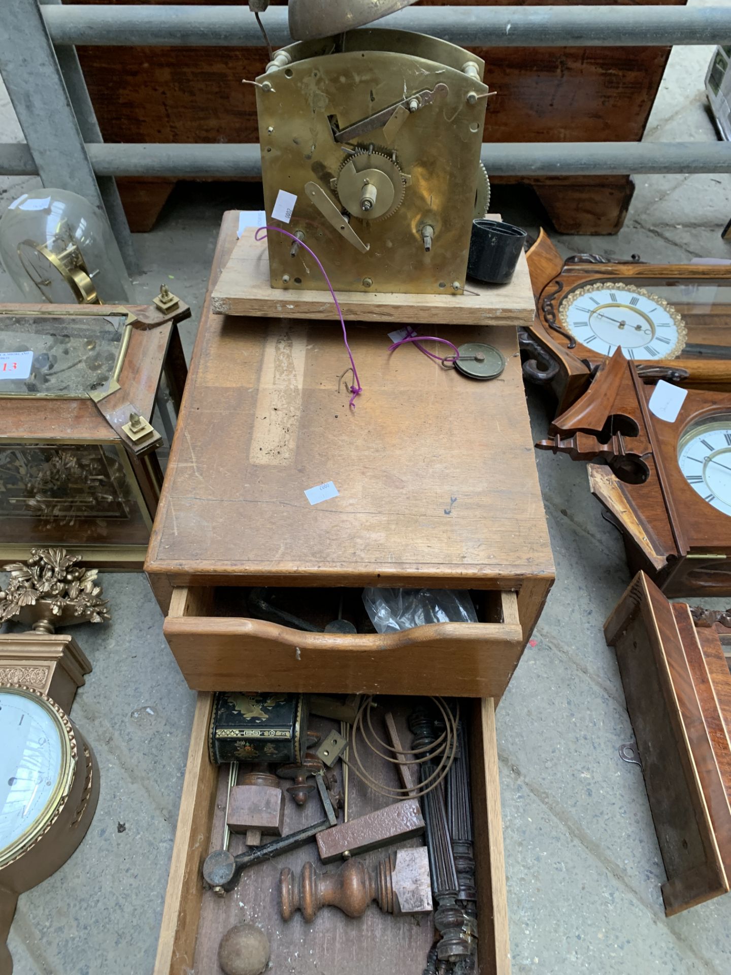Clock movement and a wooden two door cabinet containing clock parts