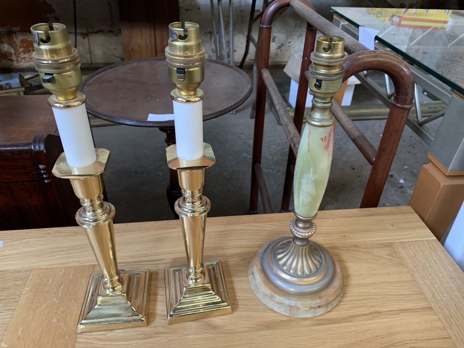 Pair of brass candlestick style table lamps; together with an onyx and brass table lamp
