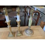 Pair of brass candlestick style table lamps; together with an onyx and brass table lamp