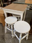 Square white painted kitchen table and three round top white painted stools