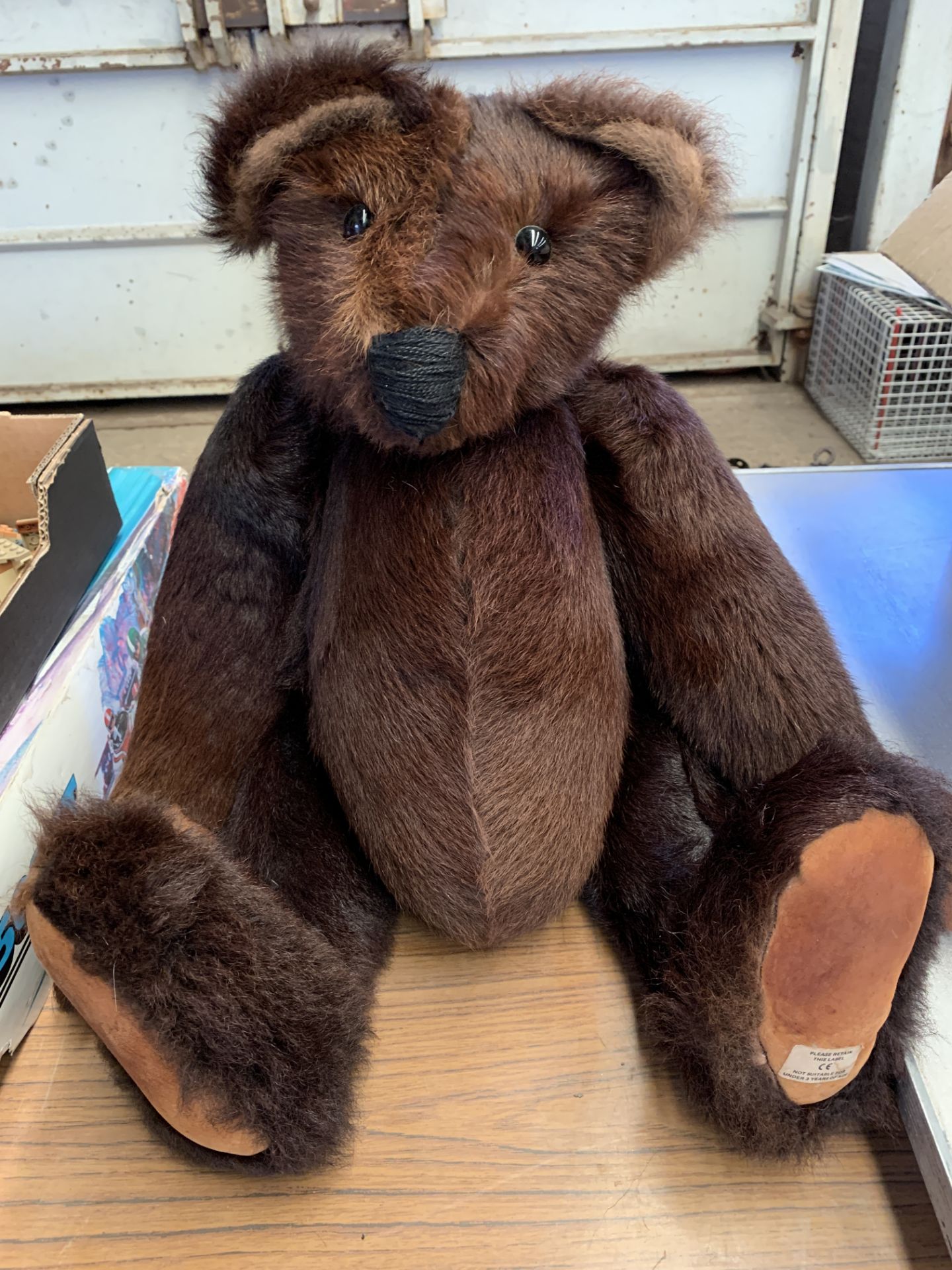 A large brown jointed teddy bear