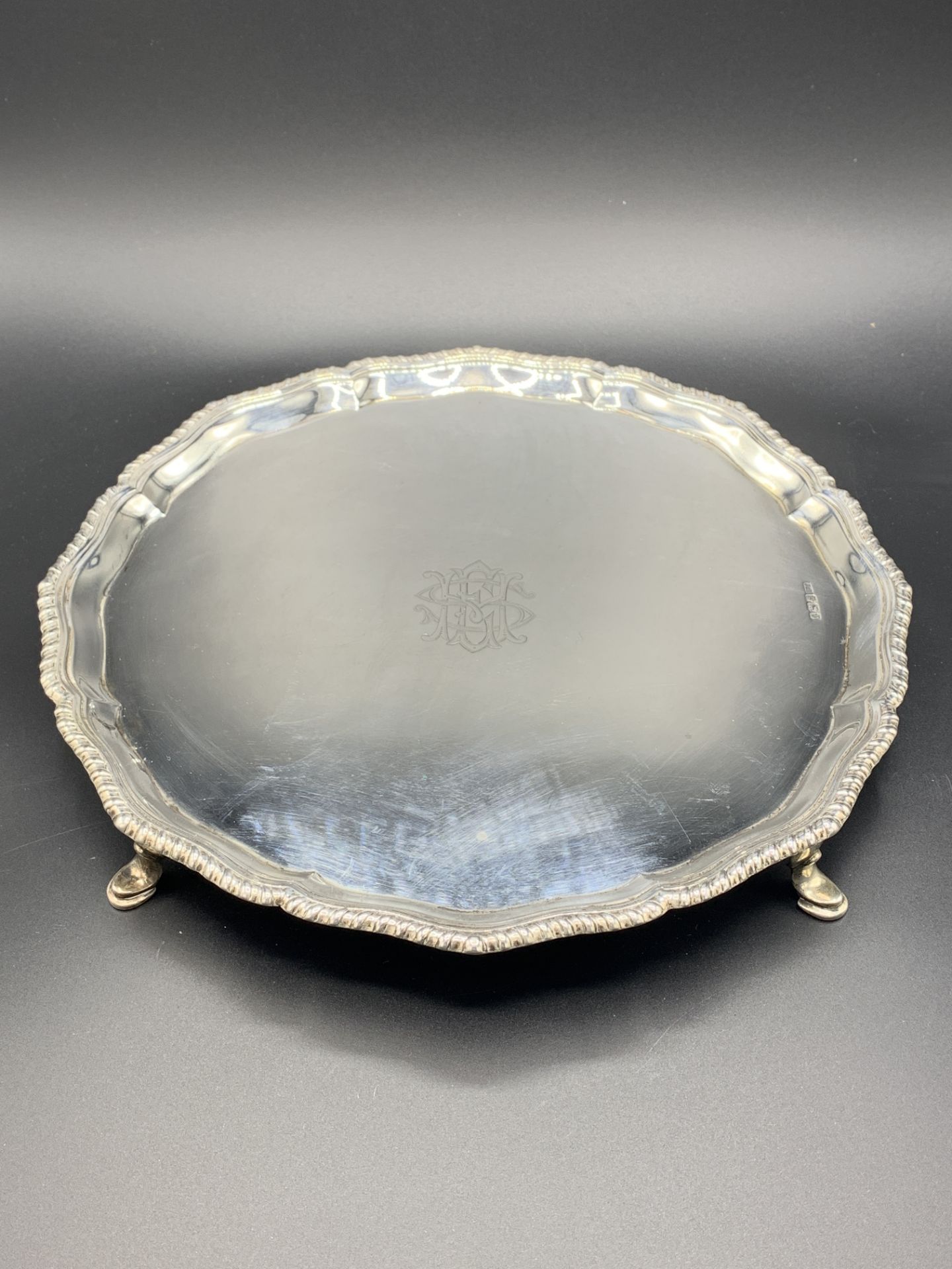 Silver scallop edged four footed salver with engraved initials, Sheffield 1913 by Stevenson & Law