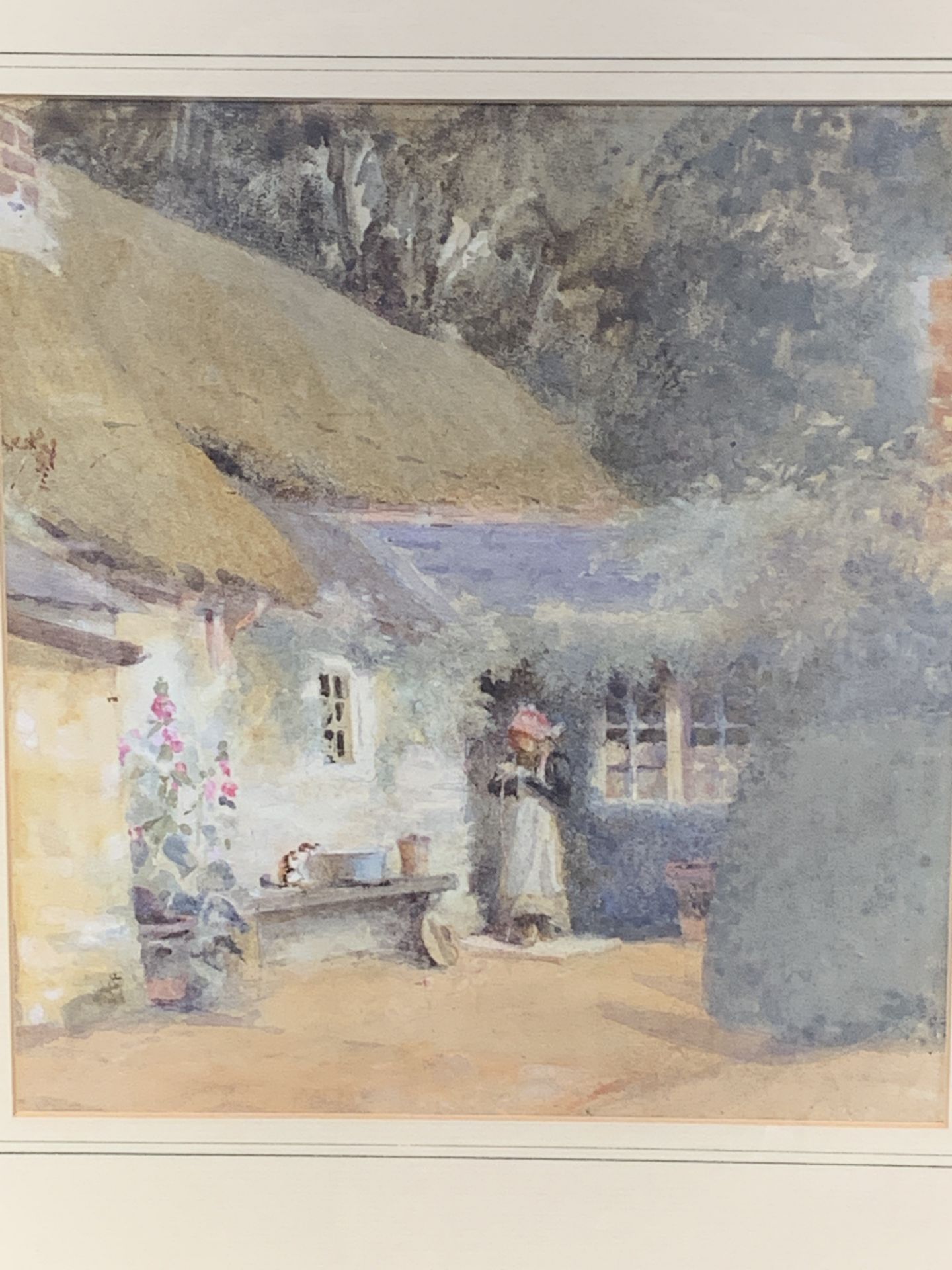 Framed and glazed watercolour of a lady in front of a country cottage