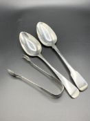 Two Georgian silver table spoons and a pair of silver sugar tongs