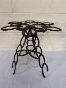 Table made of old horseshoes, suitable as a garden ornament.
