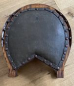 Vintage oak horseshoe shaped footstool from the USA, with oilcloth covered padding and carved horses