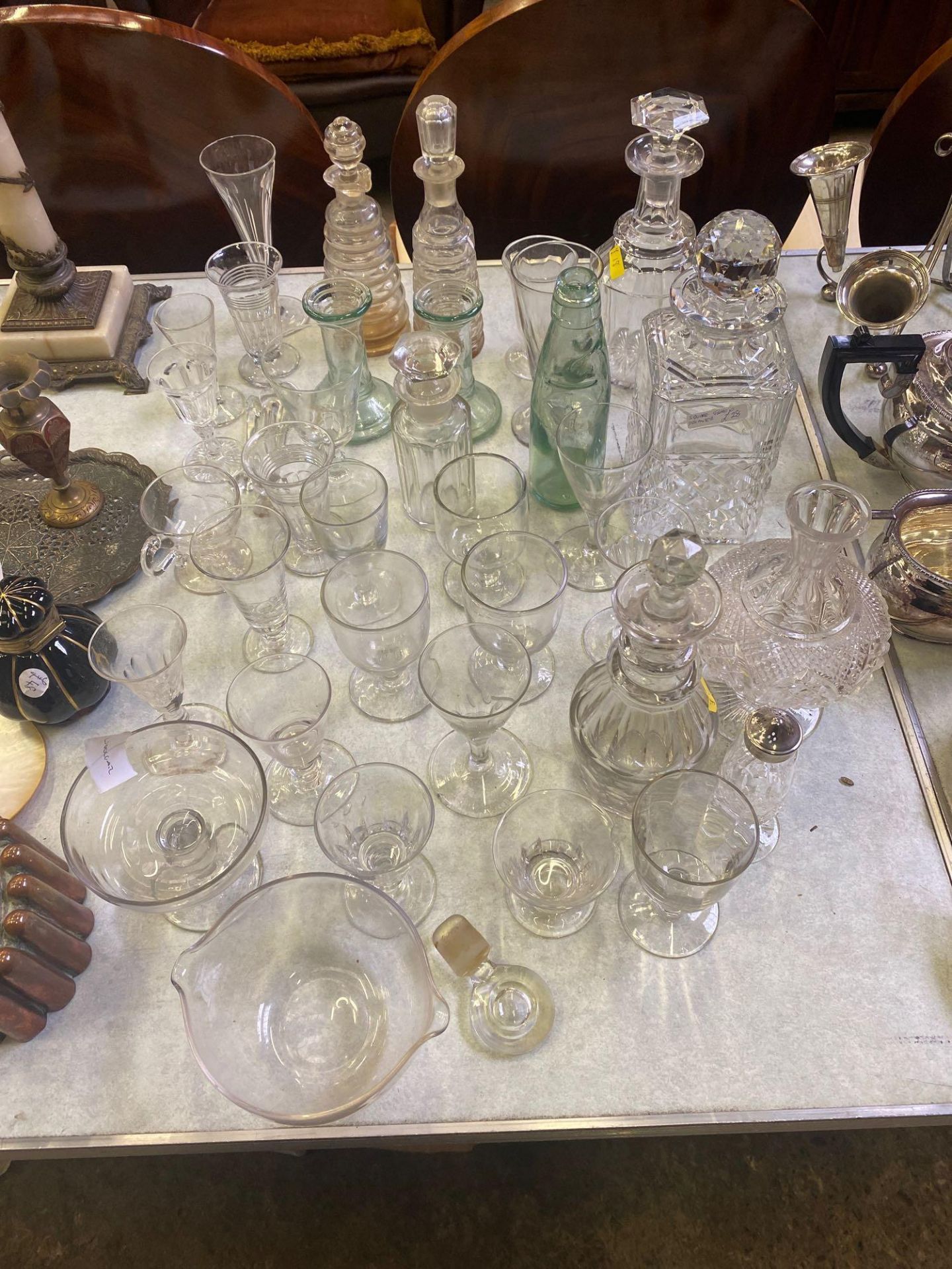 Four glass decanters together with a quantity of other glass.