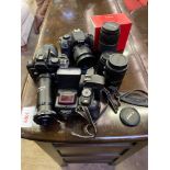Three Canon EOS cameras with associated lenses and equipment