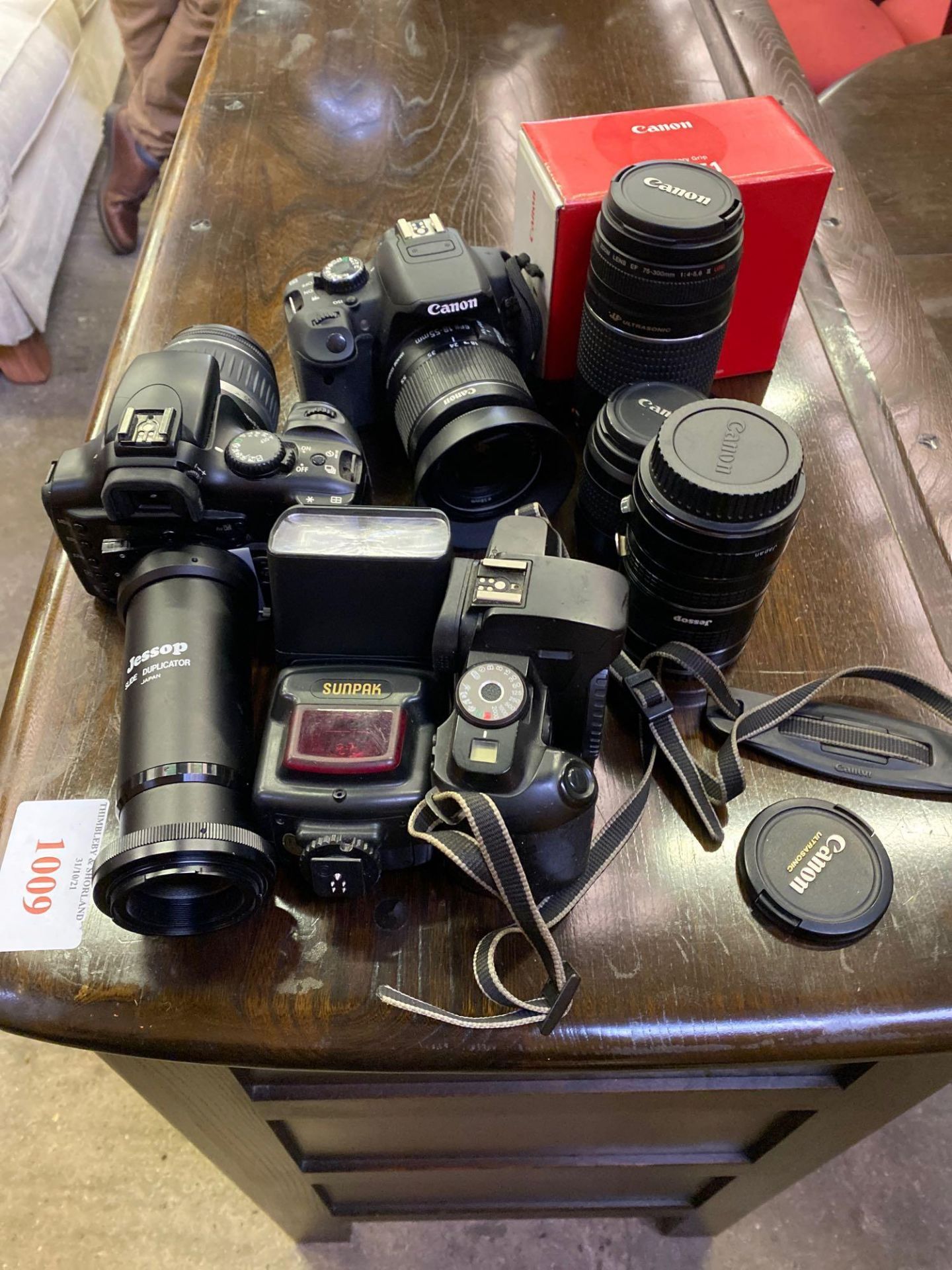 Three Canon EOS cameras with associated lenses and equipment