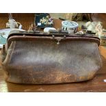 A small brown leather Gladstone bag containing antique dentists' tools, and a briefcase