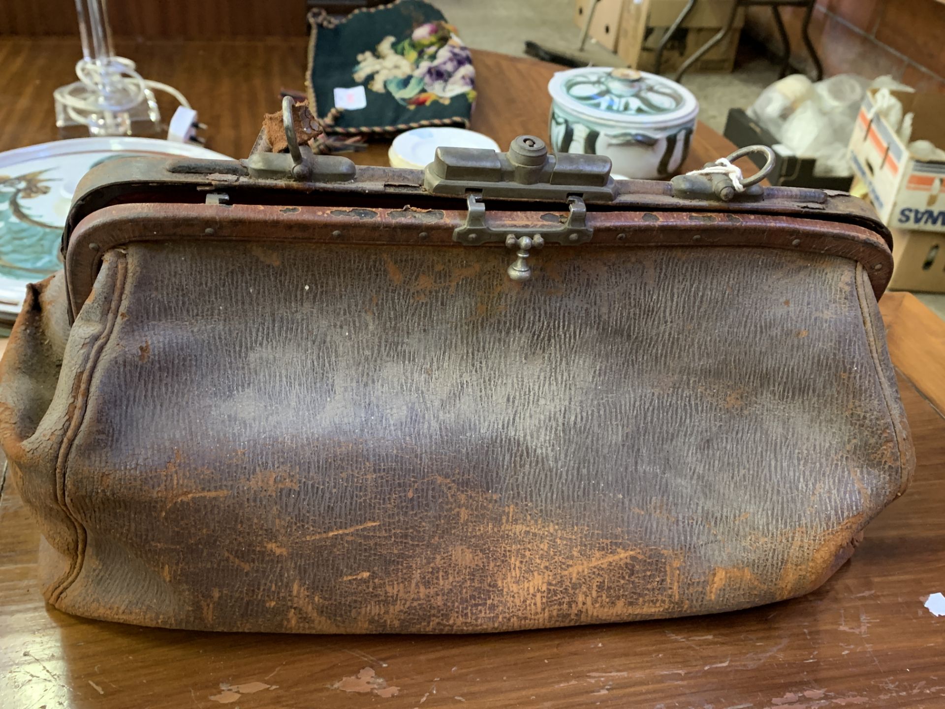 A small brown leather Gladstone bag containing antique dentists' tools, and a briefcase