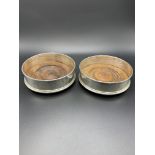 A pair of hallmarked silver and mahogany bottle coasters