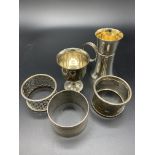 A hallmarked silver and gilt drinks measure, a silver egg cup, and three silver napkin rings