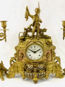 A brass mantel clock and candelabra garniture set