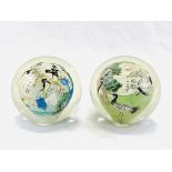 Two reverse painted Japanese glass paperweights, painted with cranes and a village scene