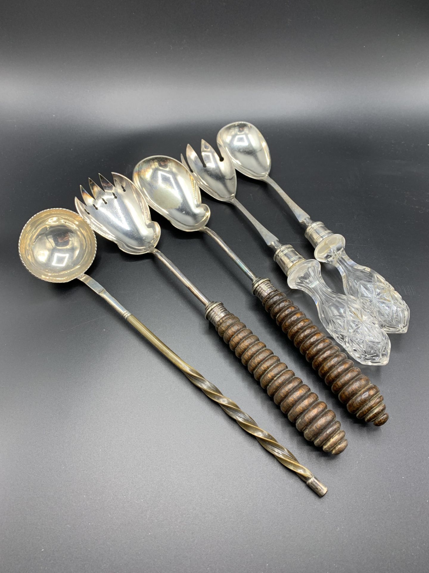 Two pairs of silver plate salad servers and a silver plate brandy ladle