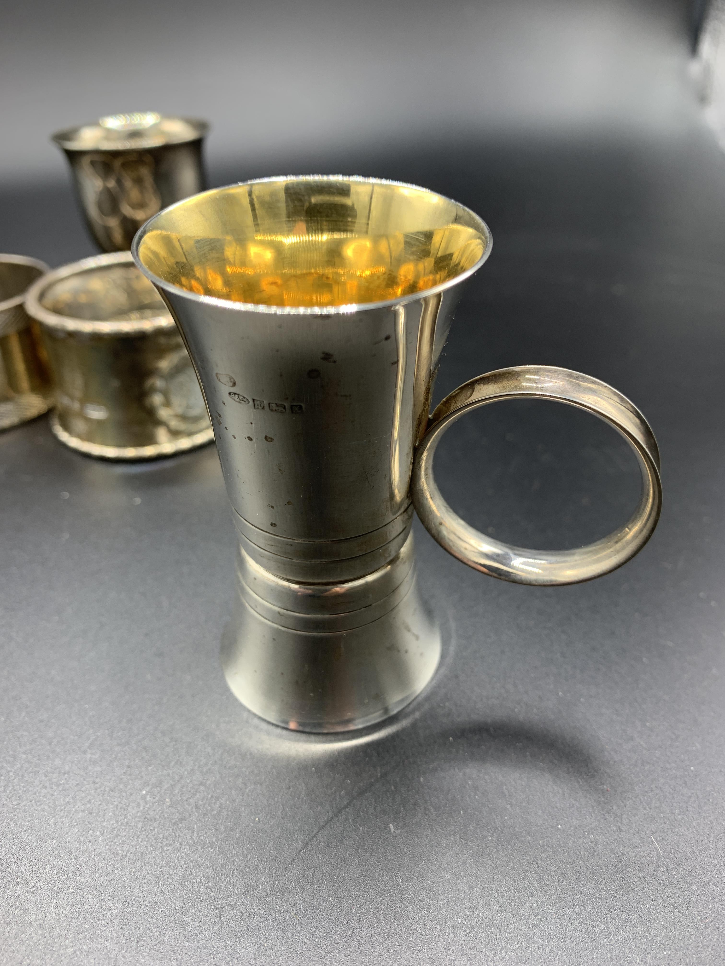 A hallmarked silver and gilt drinks measure, a silver egg cup, and three silver napkin rings - Image 3 of 4