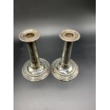 A pair of silver columned candlesticks hallmarked Sheffield 1904