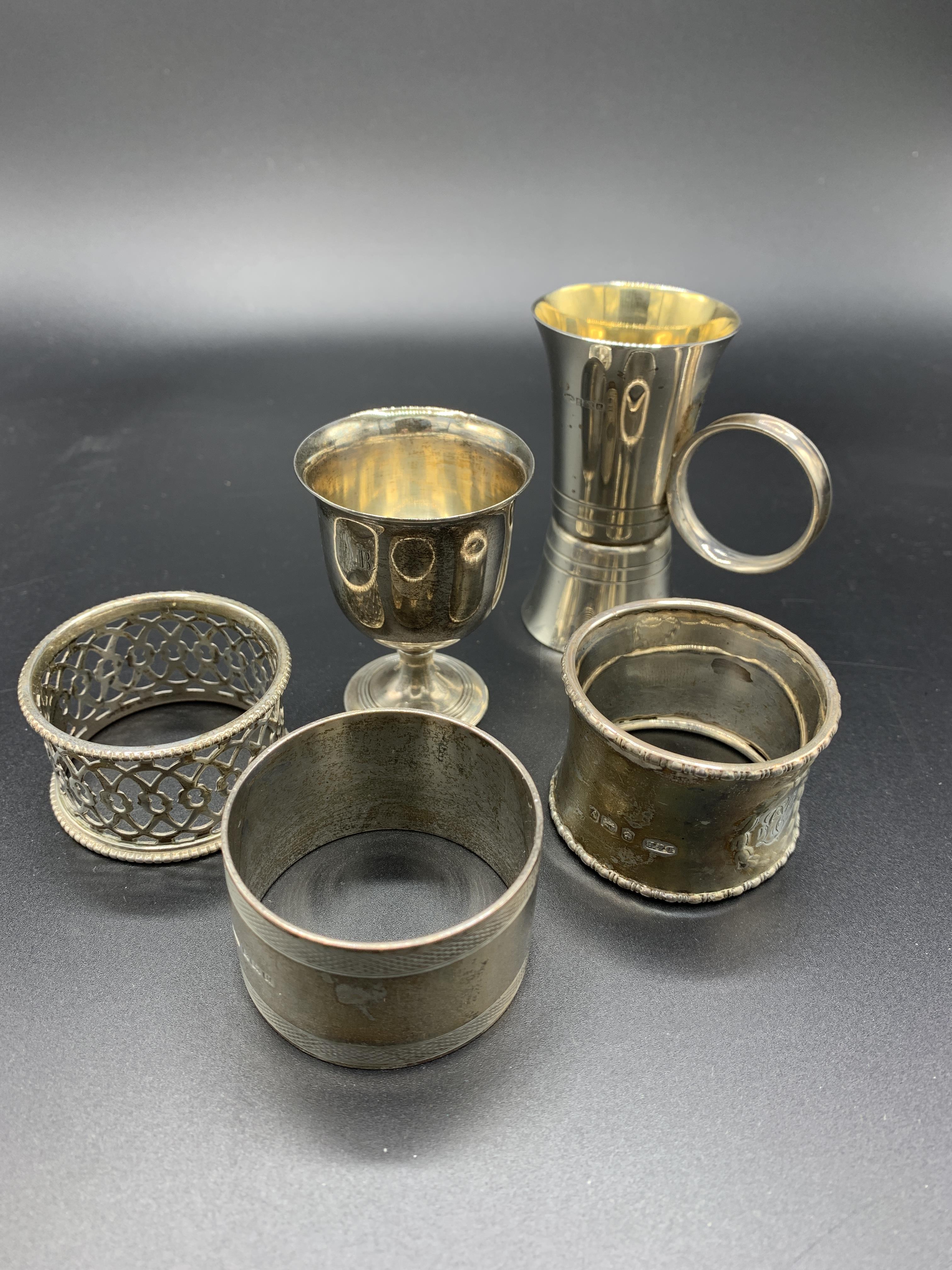 A hallmarked silver and gilt drinks measure, a silver egg cup, and three silver napkin rings - Image 4 of 4