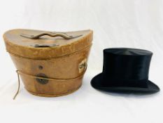 A silk top hat together with a leather hat box