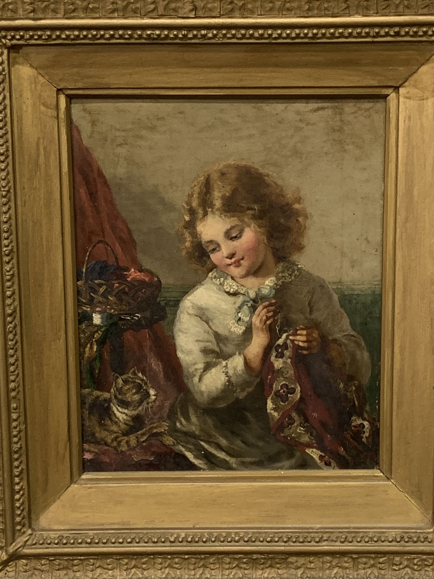 Framed oil on canvas of a girl sewing