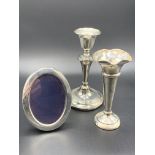 A hallmarked silver bud vase, candlestick, and frame