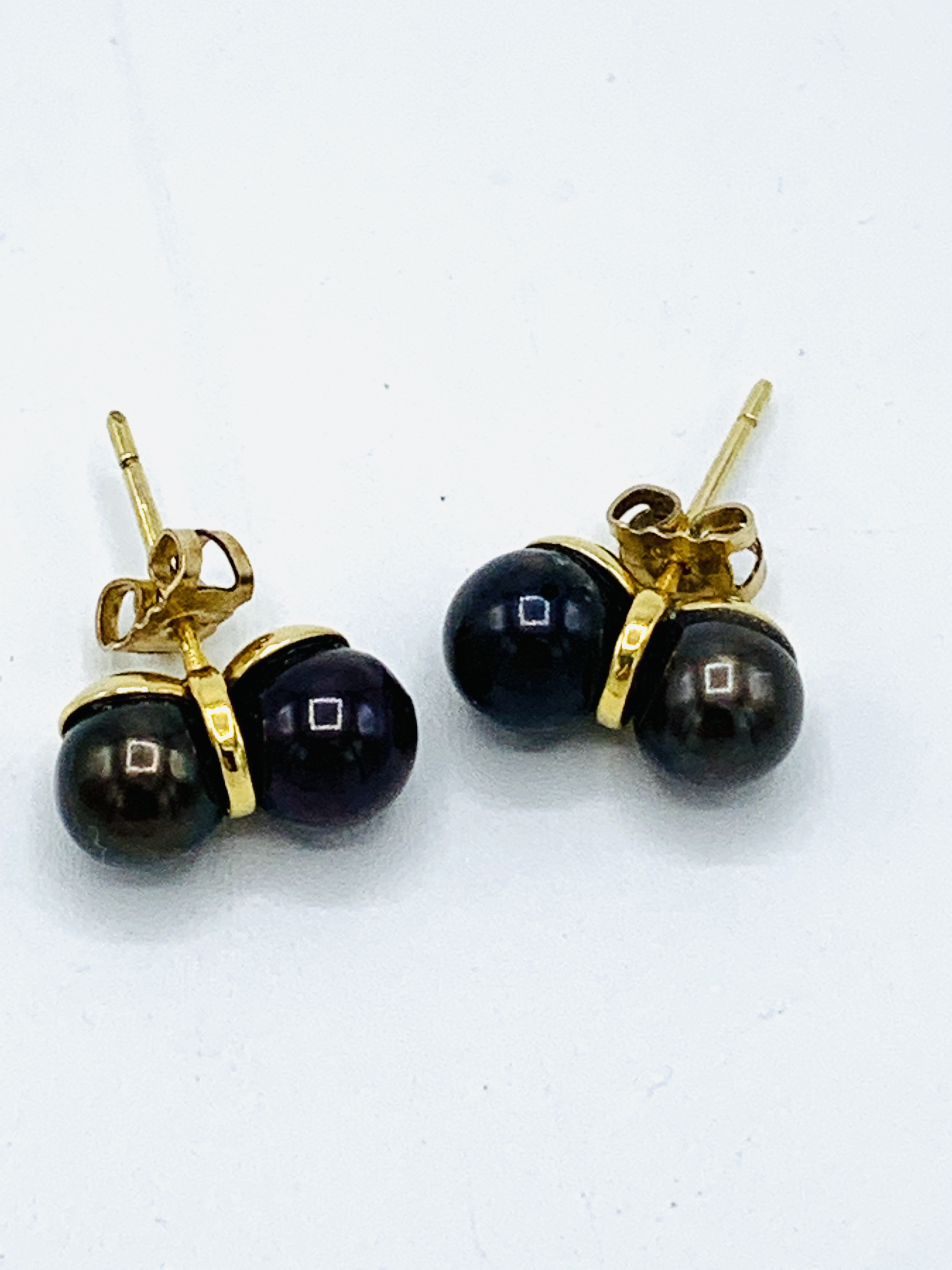 A pair of 9ct gold double black pearl set stud earrings