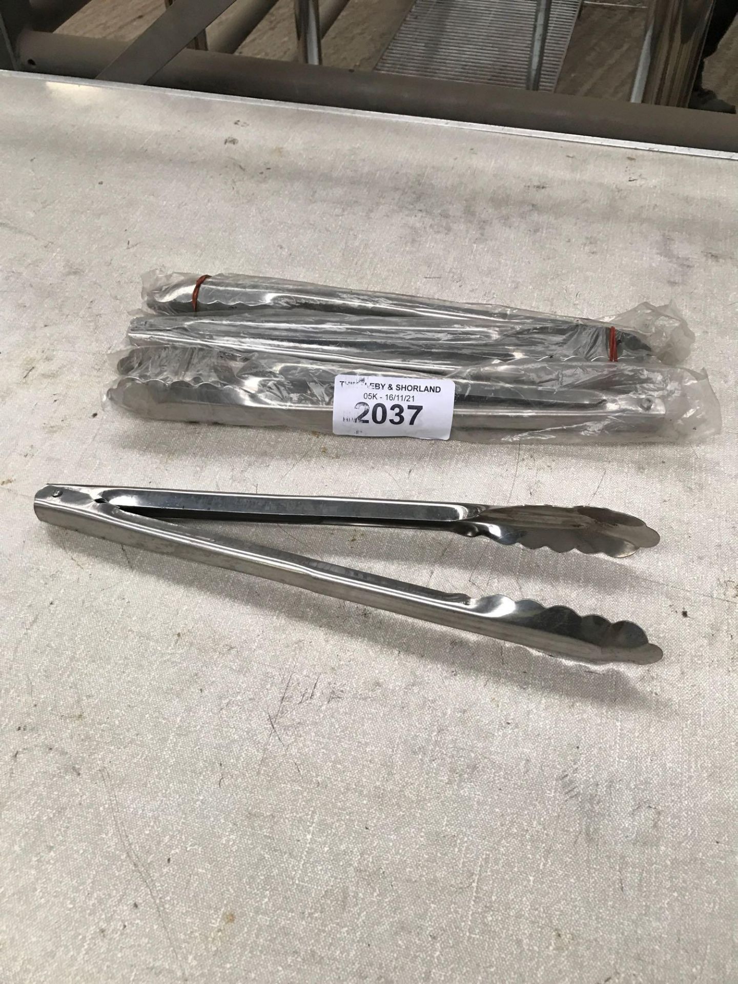 Four stainless steel tongs