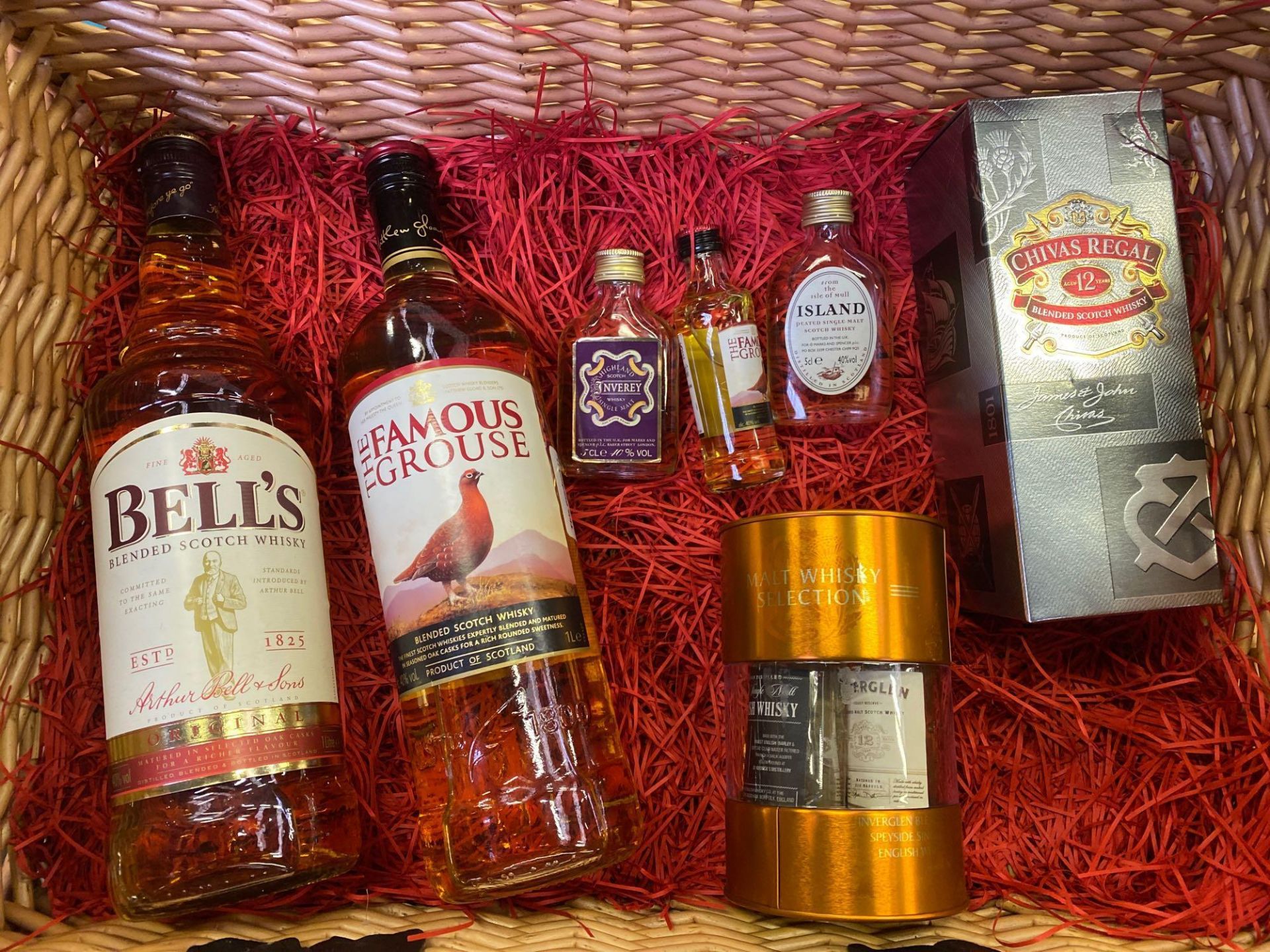 A wicker hamper containing a quantity of whiskies