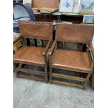 A pair of oak framed open armchairs upholstered in brown studded leather