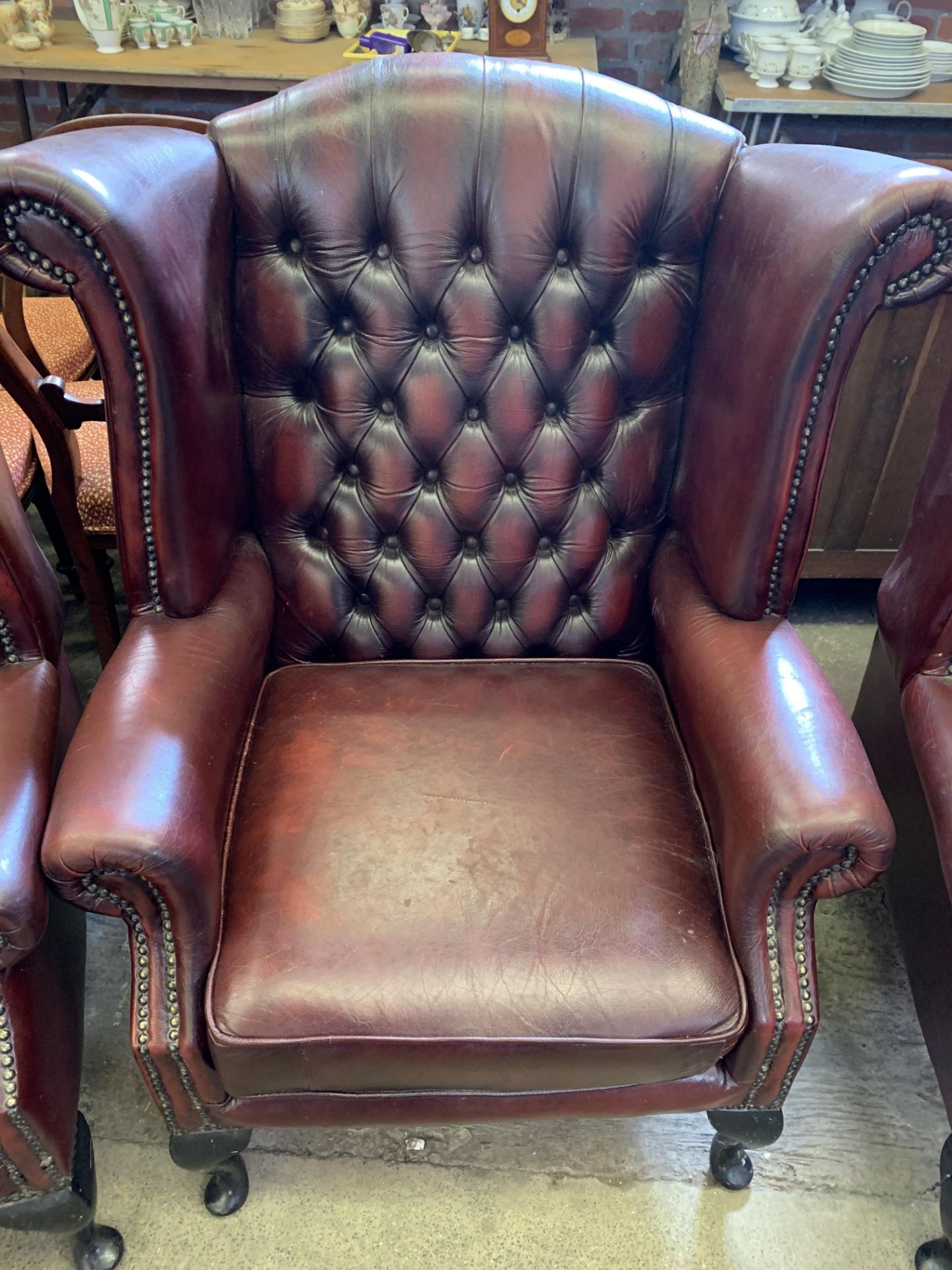 Red button leather-effect wing back armchair