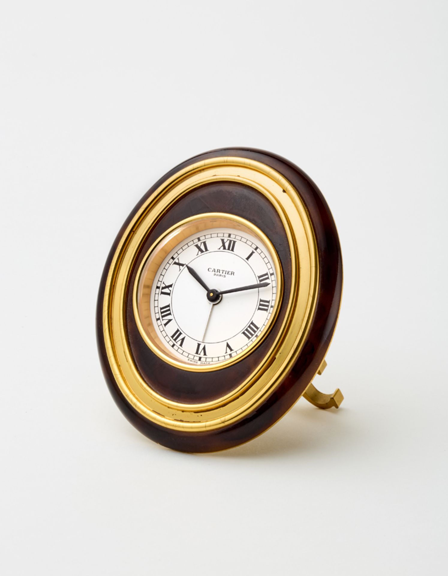 CARTIERElliptical lacquered gilt brass alarm clock with mechanical movement.70s of the twentieth