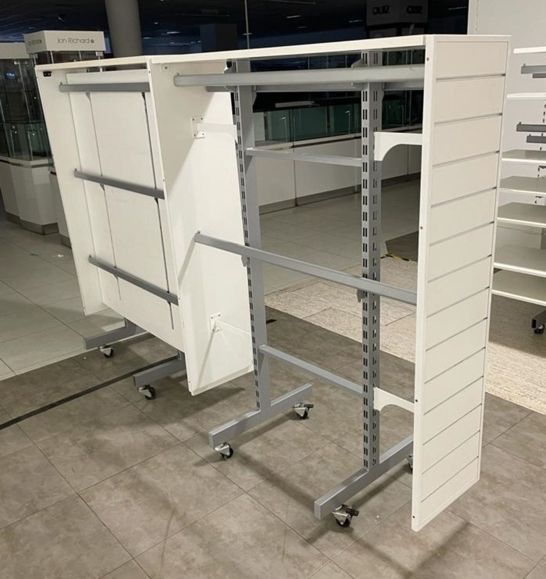 2 x Retail Display Units in White Featuring Clothes Rails, Slat Walls and Castor Wheels - Size