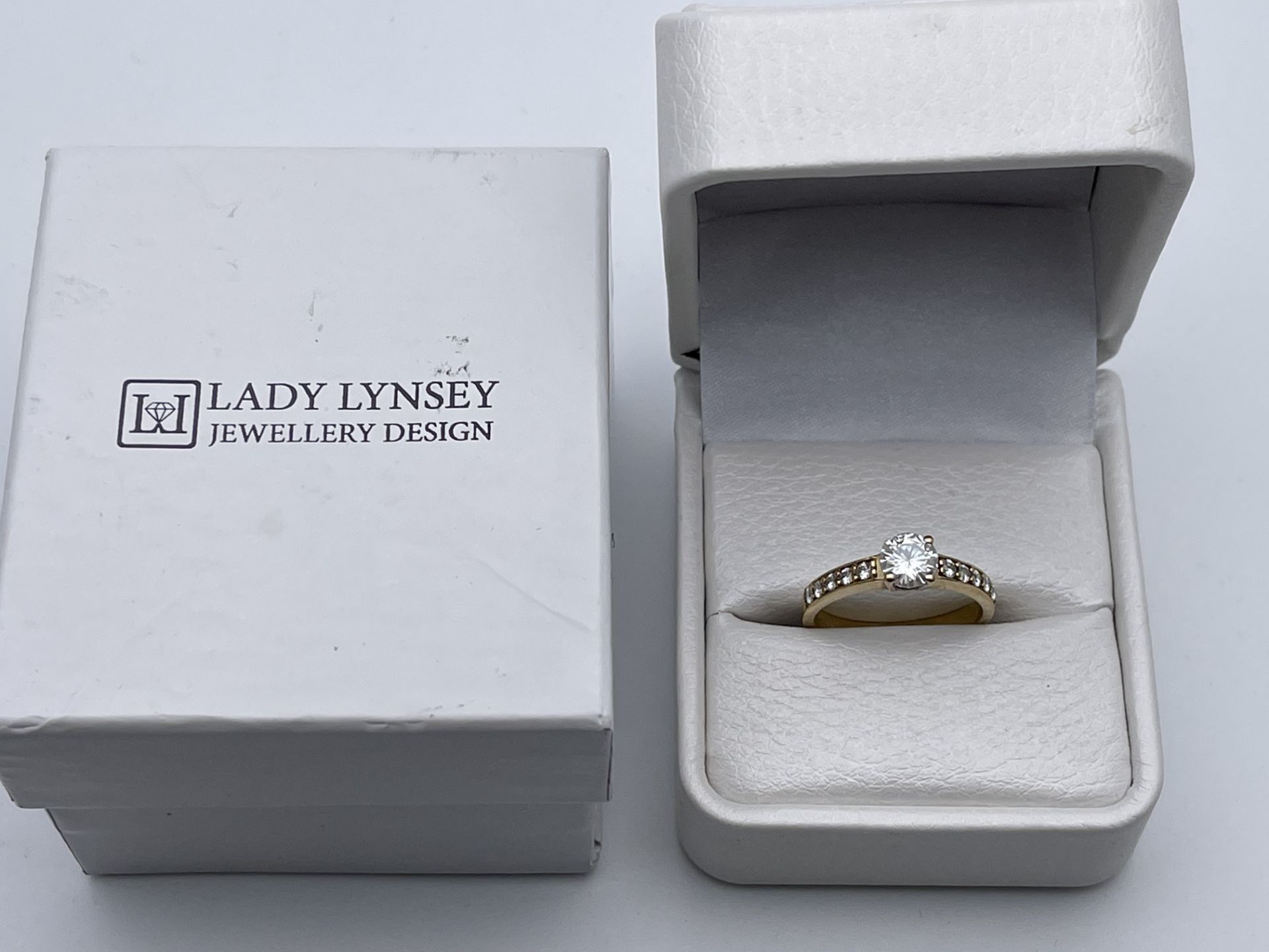 BOXED LADY LYNSEY JEWELLERY DESIGN, 9CT YELLOW GOLD SOLITAIRE RING, SET WITH STONES ON THE SHANK,