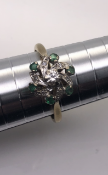 18ct yellow gold ring Set with 6 emeralds Swirl set diamonds and a diamond central stone approx 0.