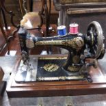 A Victorian sewing machine in wooden case