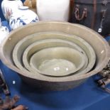 A set of four brass graduated dairy bowls, early 1