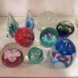 Eight Caithness glass paperweights and a bubble gl