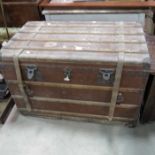 A large travelling trunk with wood and leather strapping